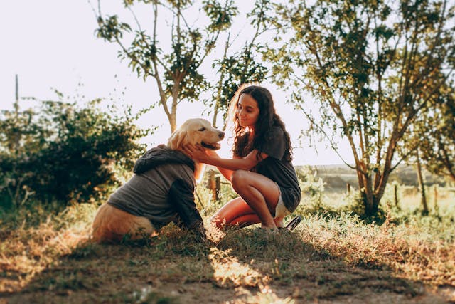 Woman caressing dog on field